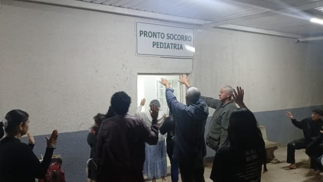 Voluntários orando com pacientes em hospital