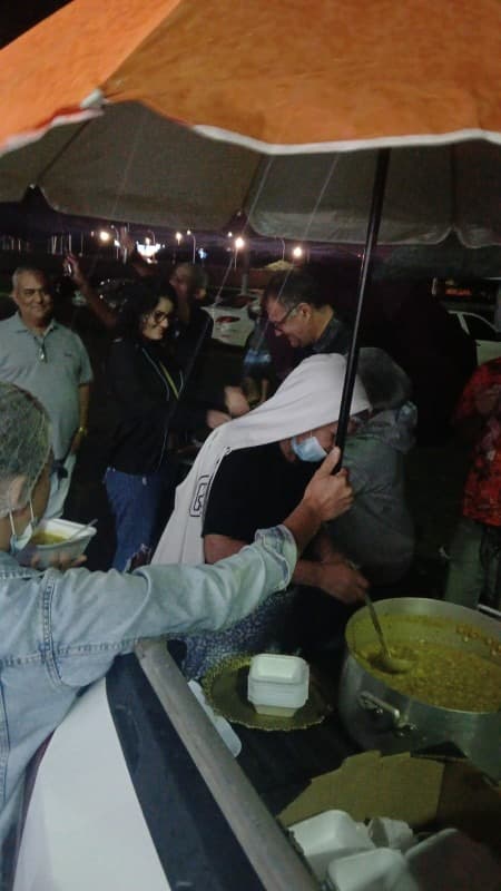 Voluntários entregando sopa à comunidade